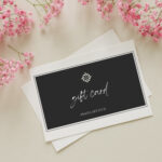 Greeting card mockup and pink  gypsophila flowers twigs on beige background top view flatlay. Card mockup with copy space.